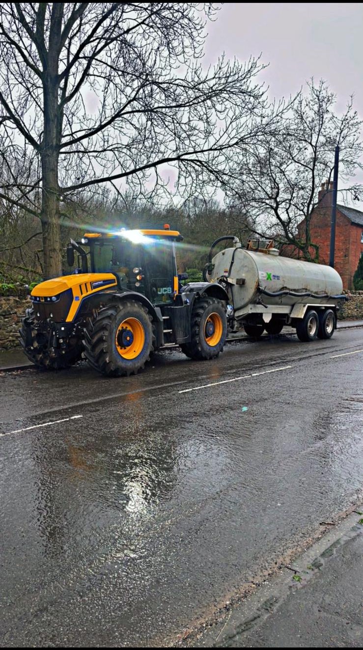 AMC JCB tractor bowser with headlights on rural road